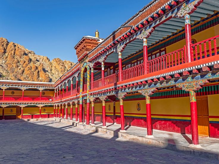 a hemis building with many pillars and a stone path