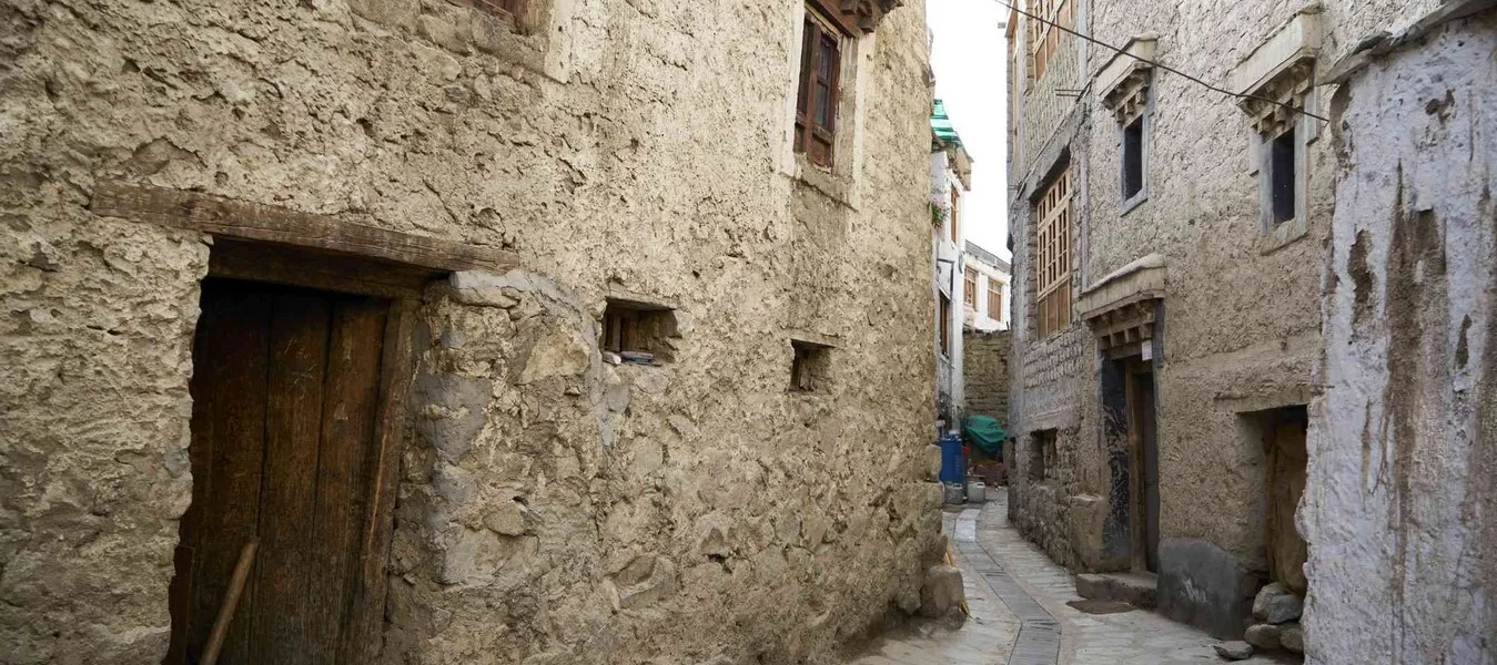 Traditional Ladakhi mud-and-stone wall along a village lane in late afternoon light