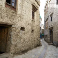 Traditional Ladakhi mud-and-stone wall along a village lane in late afternoon light